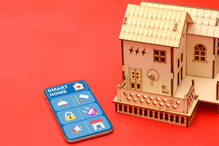 Smart home mobile screen with house miniature.の写真素材