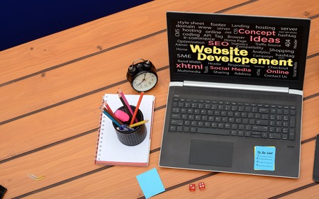 Web development theme with laptop screen on wooden backgroundの写真素材