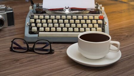 Typewriter on the old wooden desk with coffee cup, writers block office deskの写真素材