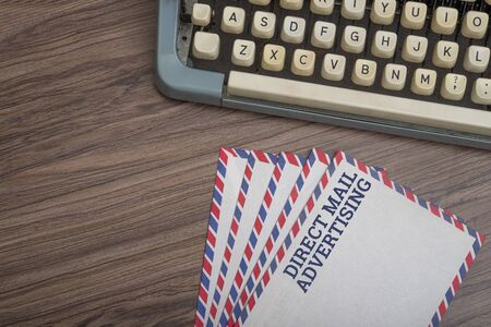 Manual typewriter with post card and envelopes on wooden background top viewの写真素材