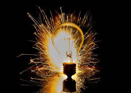 Electricity spark with bulb on black background with idea conceptの写真素材