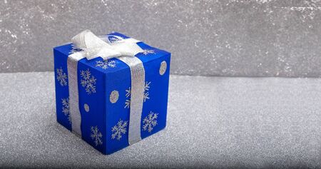 Blue color christmas gift box with snow background, copy space bannerの写真素材