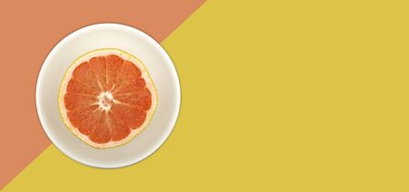 Fresh grapefruit on multi color background top view banner with copy space.の写真素材
