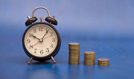 Silver coin with investment alarm clock, starting business growth concept.