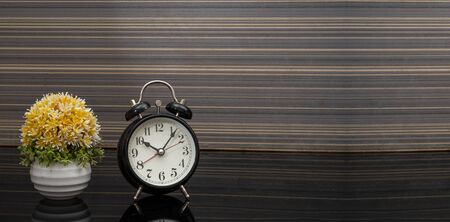 Vintage style alarm clock on wooden background banner with copy space.の写真素材