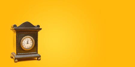 Old vintage style alarm clock on yellow background banner with copy space.