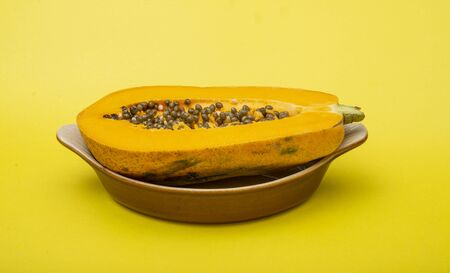 Close up photo of papaya on yellow background with copy space