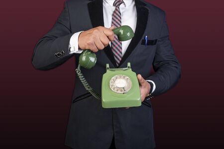 Businessman holding landline Phone in hands contact us conceptの写真素材