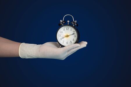 Doctor hand with glove hold hand watch, checkup time concept and copy spaceの写真素材