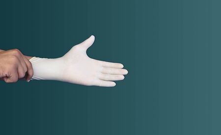 Man puts medical protective glove on his hands, corona virus concept