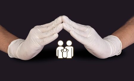 Doctors Hands with gloves protecting family medical and healthcare conceptの写真素材