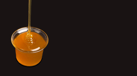 Natural honey filled jar on black banner template.の写真素材