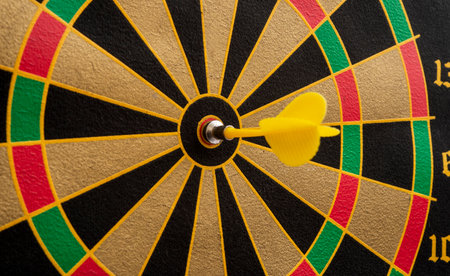 Yellow dart arrow hitting in the target spot of dartboard success concept.の写真素材