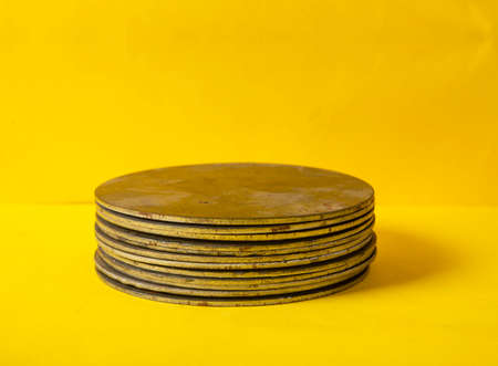 Pieces of steel pile up on yellow background for your product mockup space.の写真素材