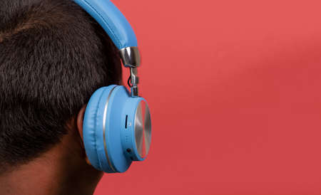 Boy listening to music with wireless headphone closeup view and copy space.