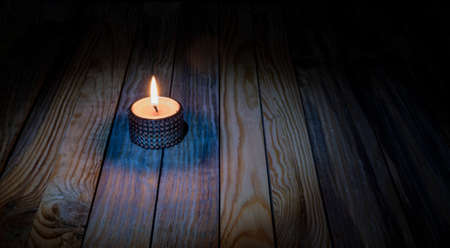 Candle light burning on wooden table memorial theme banner.