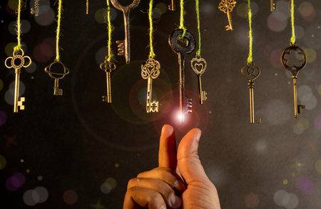 Selecting the right direction theme with vintage keys with hand on dark banner.の写真素材