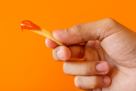 French fries and Ketchup with hand holdingの写真素材