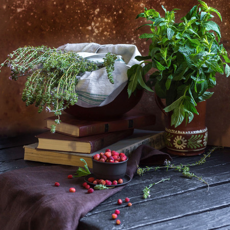 A bouquet in a brown vase and strawberries. Rustic still lifeの写真素材