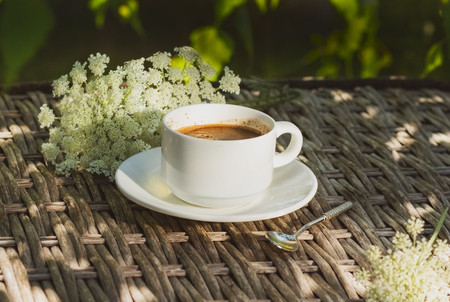 A cup of coffee on a background of flowersの写真素材