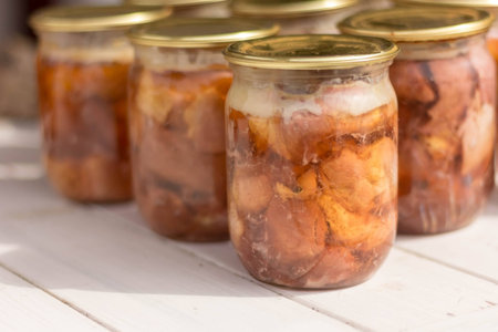 Canned meat in a glass jar on a white wooden tableの写真素材
