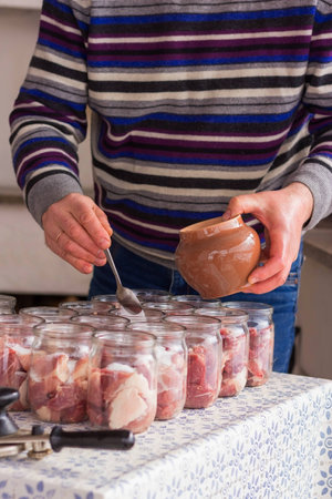 The chef prepares a meat stew in the kitchen near the ovenの写真素材
