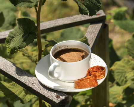 A cup of coffee in the garden against a backdrop of bushesの写真素材