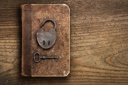 Antique Padlock with key on old bookの写真素材