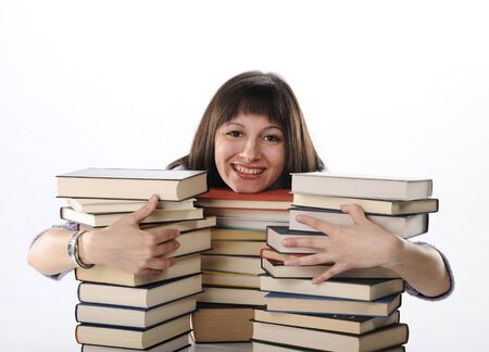 young woman behind a big pile of books 