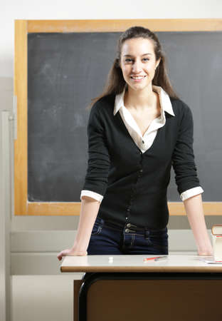 Portrait of a young woman, teacher in front of a blackboardの写真素材
