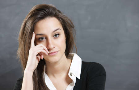 thinking woman in front of blank blackboard