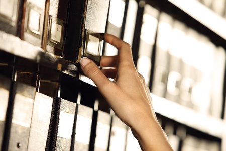 Searching in archives. Student hands searching from a filling cabinet. の写真素材