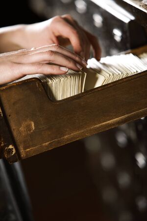 Searching in archives. Student hands searching from a filling cabinet. の写真素材