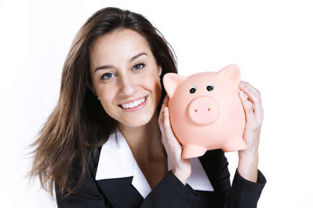 Close-up of young woman holding piggy bank against white backgroundの写真素材