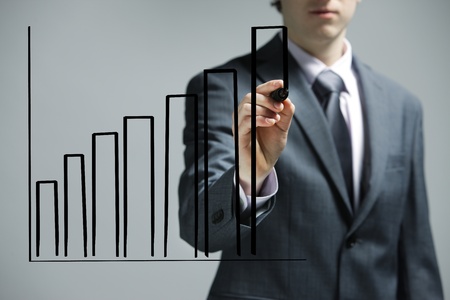 Businessman drawing a uptrend chart on screenの写真素材