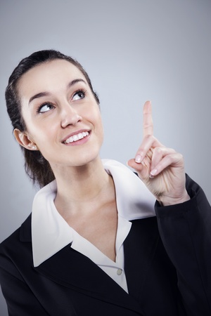 Young beautiful businesswoman pointing at copyspaceの写真素材