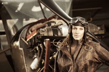 Portrait of young woman airplane pilot. Airplane on the backgroundの写真素材