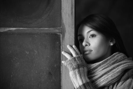 Portrait of a beautiful woman at window の写真素材