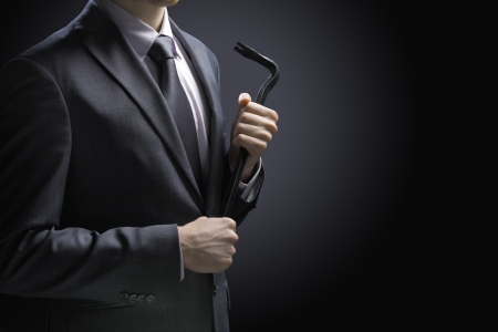 Businessman burglar with crowbar on black backgroundの写真素材