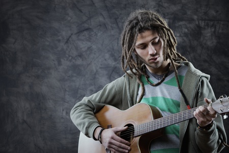 Young man playing acoustic guitarの写真素材