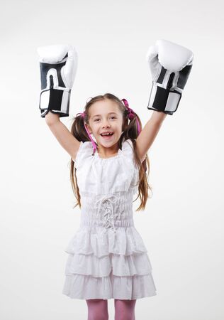 Smiling little girl wearing boxing glovesの写真素材
