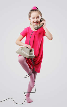 Cute young girls talking on vintage phoneの写真素材