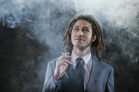 Rastafarian businessman smoking marijuanaの写真素材
