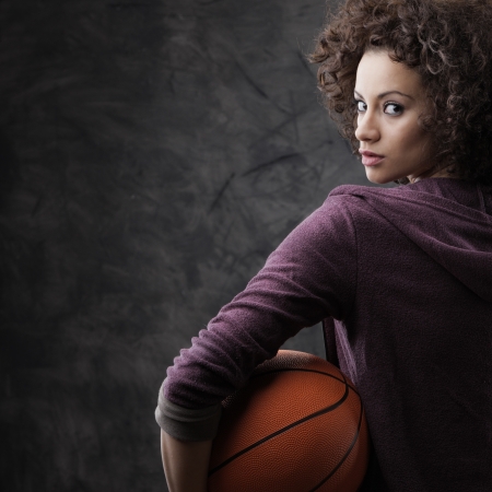 Portrait of young beautiful woman holding a basketballの写真素材