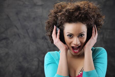 Happy woman listening music at headphones