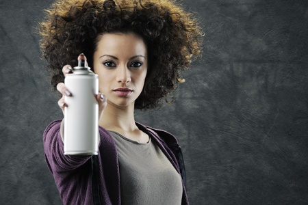 Beautiful girl about to draw a graffiti on a wall with copyspaceの写真素材