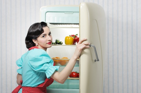 Beautiful woman posing with an open refrigeratorの写真素材