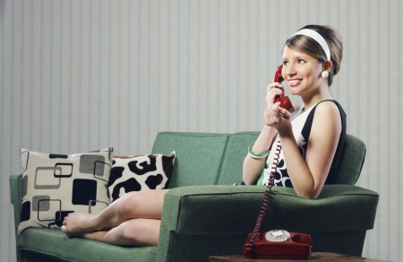 Attractive young woman on couch  talking on the phoneの写真素材