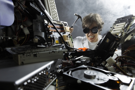 Crazy computer technician is trying to repair a computerの写真素材