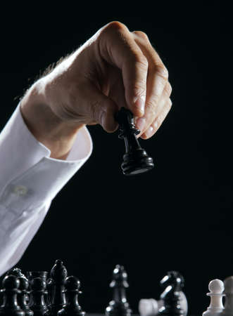 Male hand moving the queen in a chess game.の写真素材